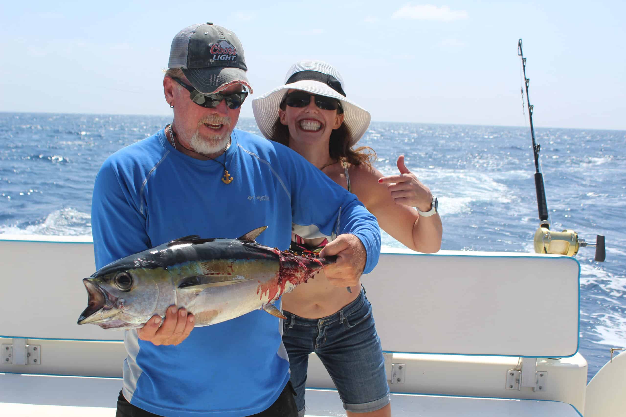 Man and Woman holding a Tuna